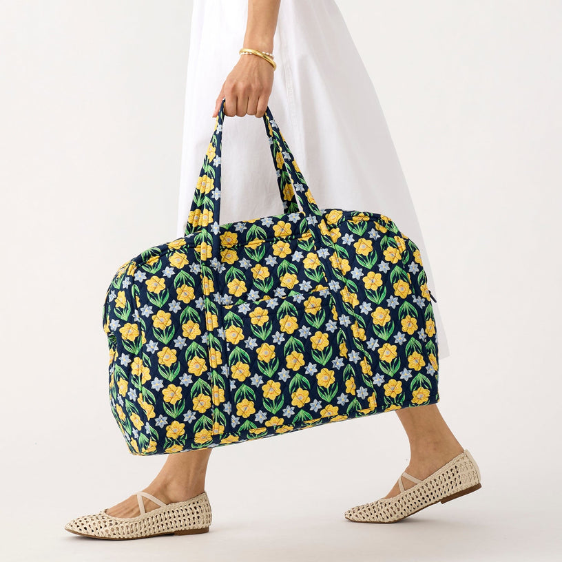 model carrying large quilted cotton gym bag with yellow and blue floral pattern