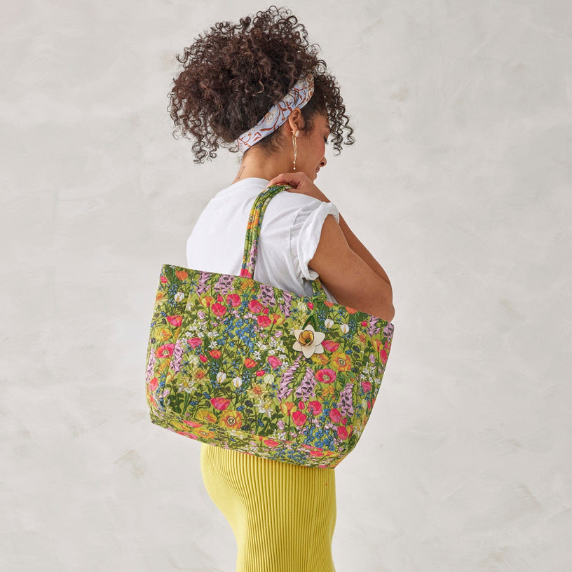model holding large floral patterned tote bag