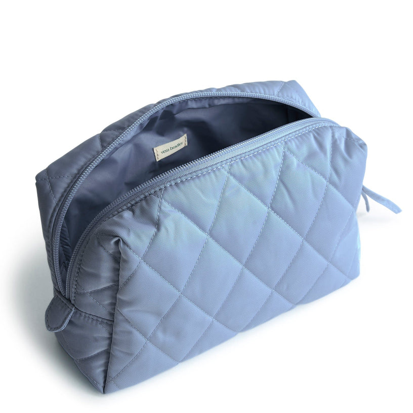 medium size blue quilted cosmetic bag shown unzipped and open