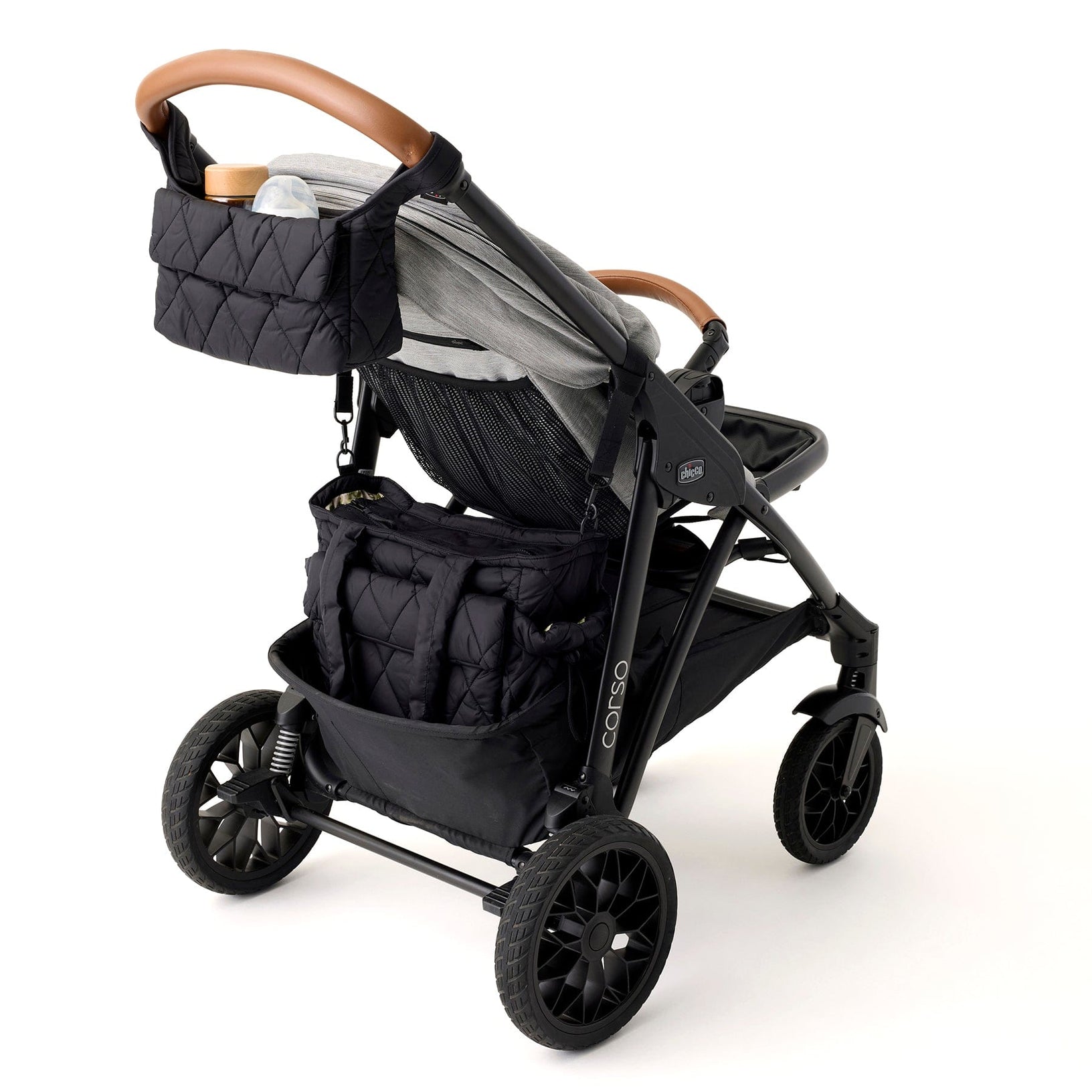 black stroller caddy attached to stroller handles and holding a baby bottle and snack container