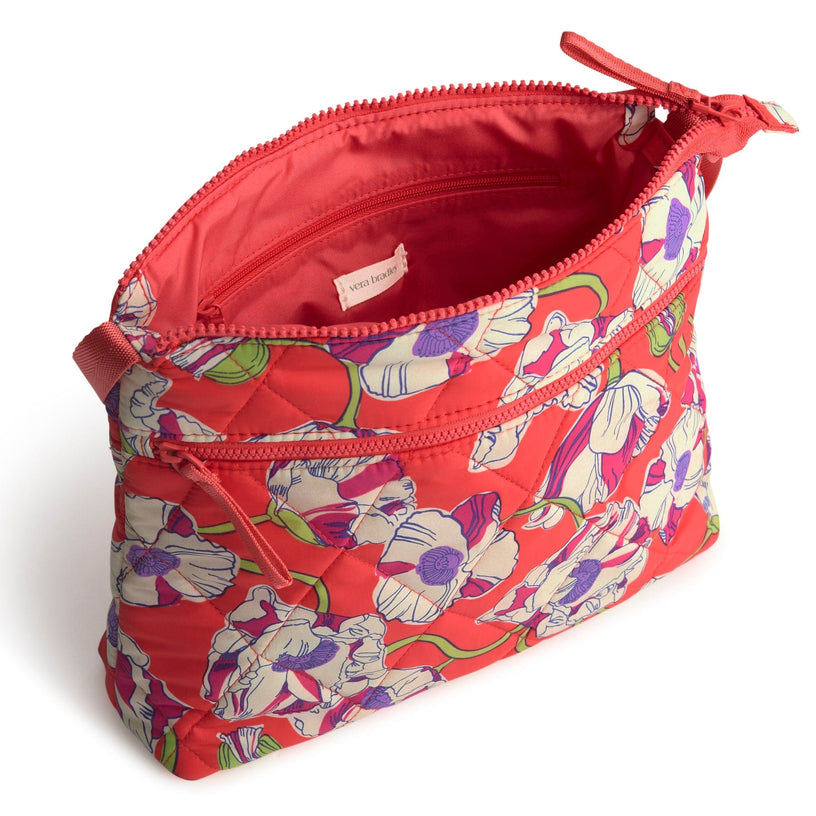 Pink floral quilted crossbody bag with zippered top open to show interior