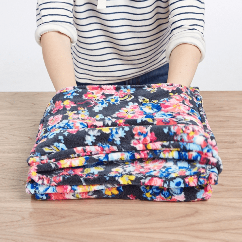 Folded floral fleece blanket on table